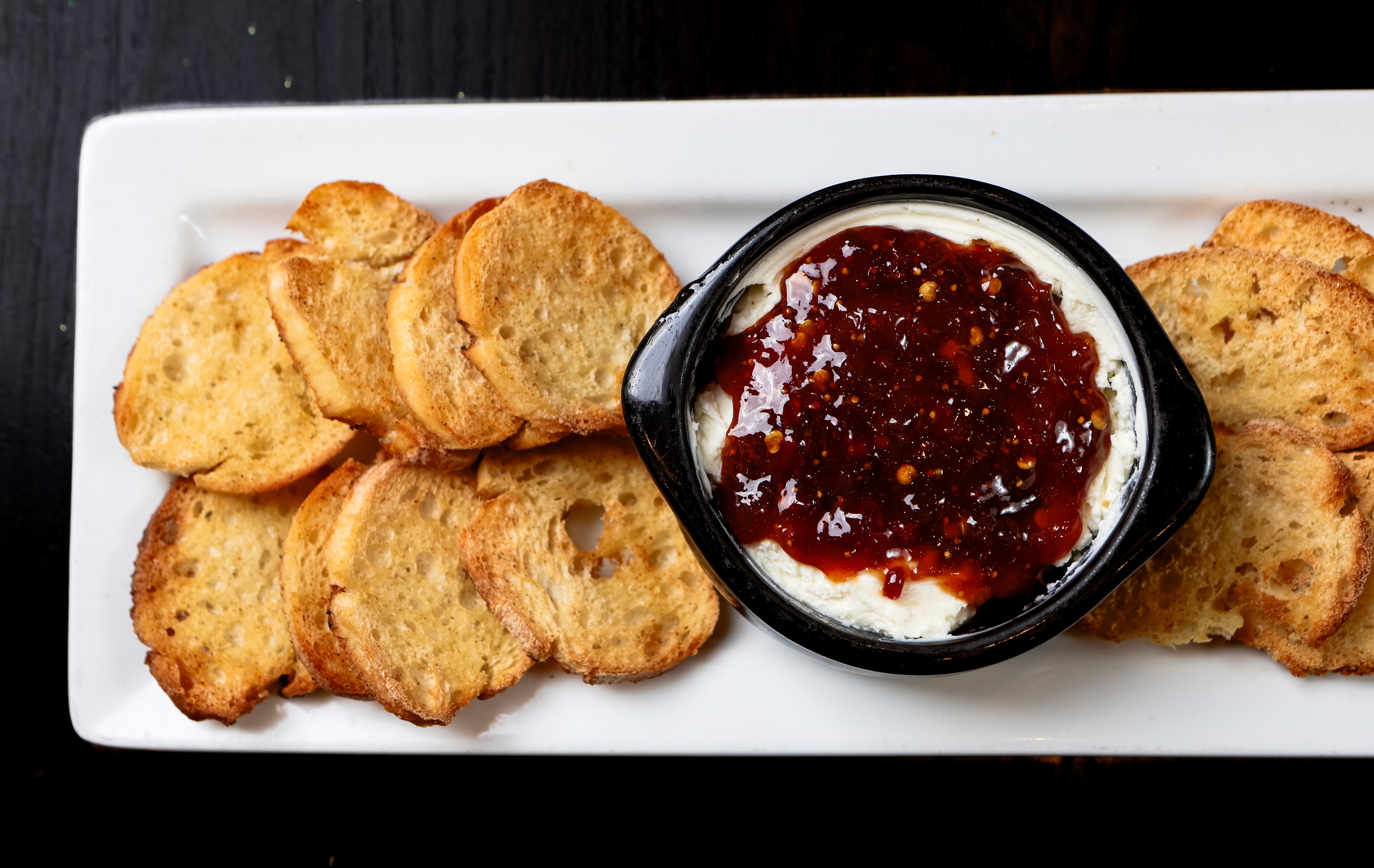 Crostini with whipped cheese and pepper jam on the bar